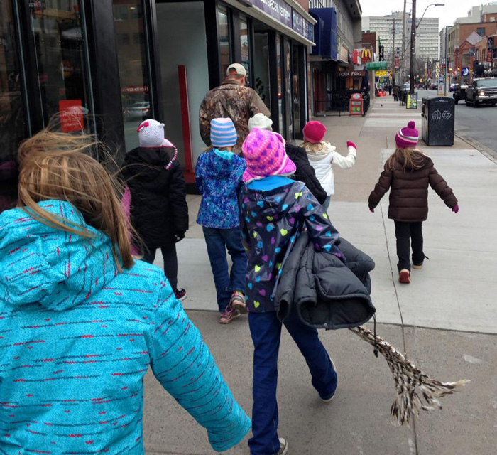 Crianças atam casacos a postes para preparar os sem-abrigo para o inverno