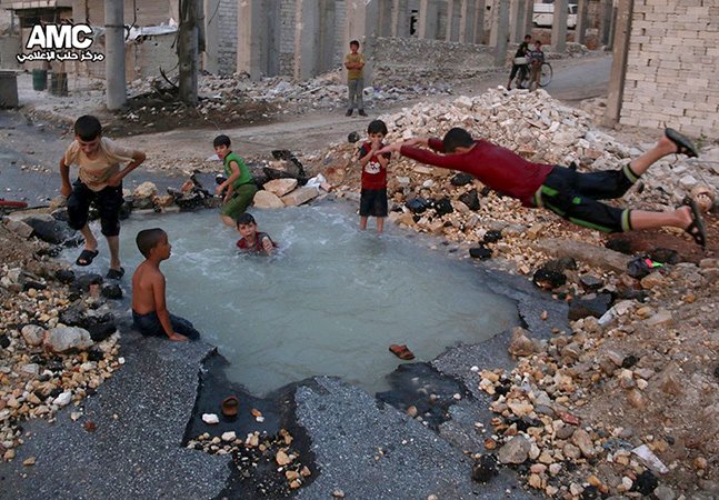 Síria: crianças brincam em &#8220;piscina&#8221; numa cratera aberta por uma bomba