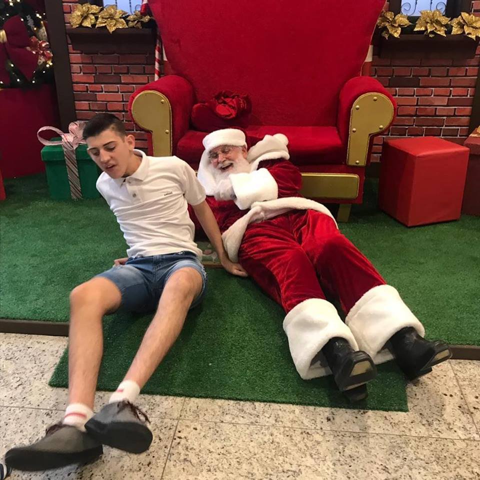 Pai Natal deita-se no chão para dar atenção a menino autista num shopping